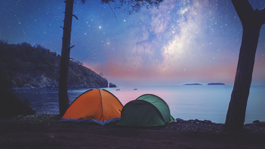 Zelten an der Küste mit hellen Sternen