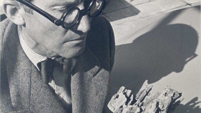 Le Corbusier betrachtet ein Holzstück