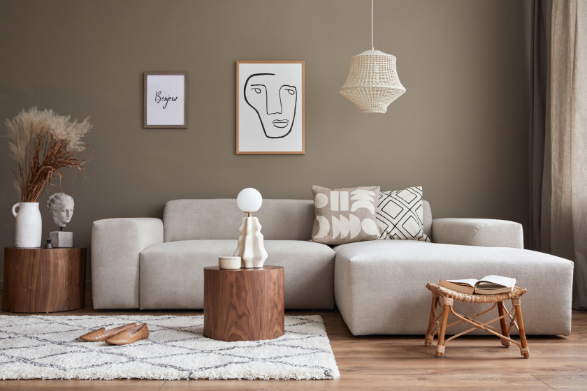 Graues Sofa mit Recamiere in einem dezent eingerichteten Wohnzimmer mit warmen Farbtönen