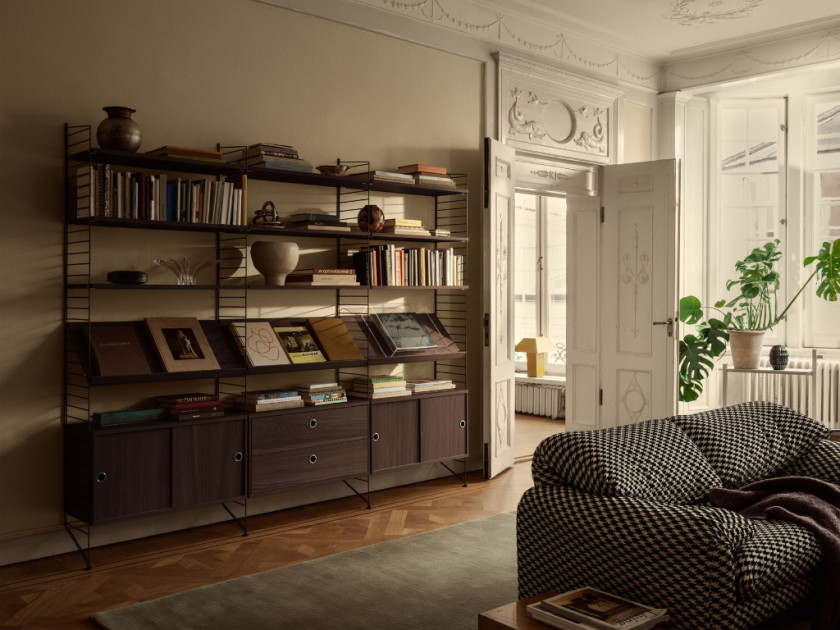 String Furniture Regalsystem mit dunklen Metallstreben und dunklem Holz als Blickfang im Altbau