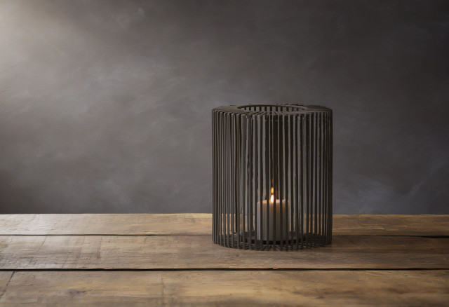 Design-Windlicht Oslo von Philippi mit schwarzem Metallgitter und Glaszylinder, beleuchtet auf rustikalem Holztisch