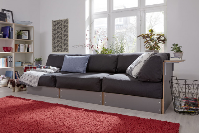Sofabank von Müller Möbelwerkstätten in grau mit anthrazitfarbenen Kissen